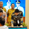 Bupati Lucky Hakim sedang menandatangani PKS Replikasi Sistem Peta Pajak